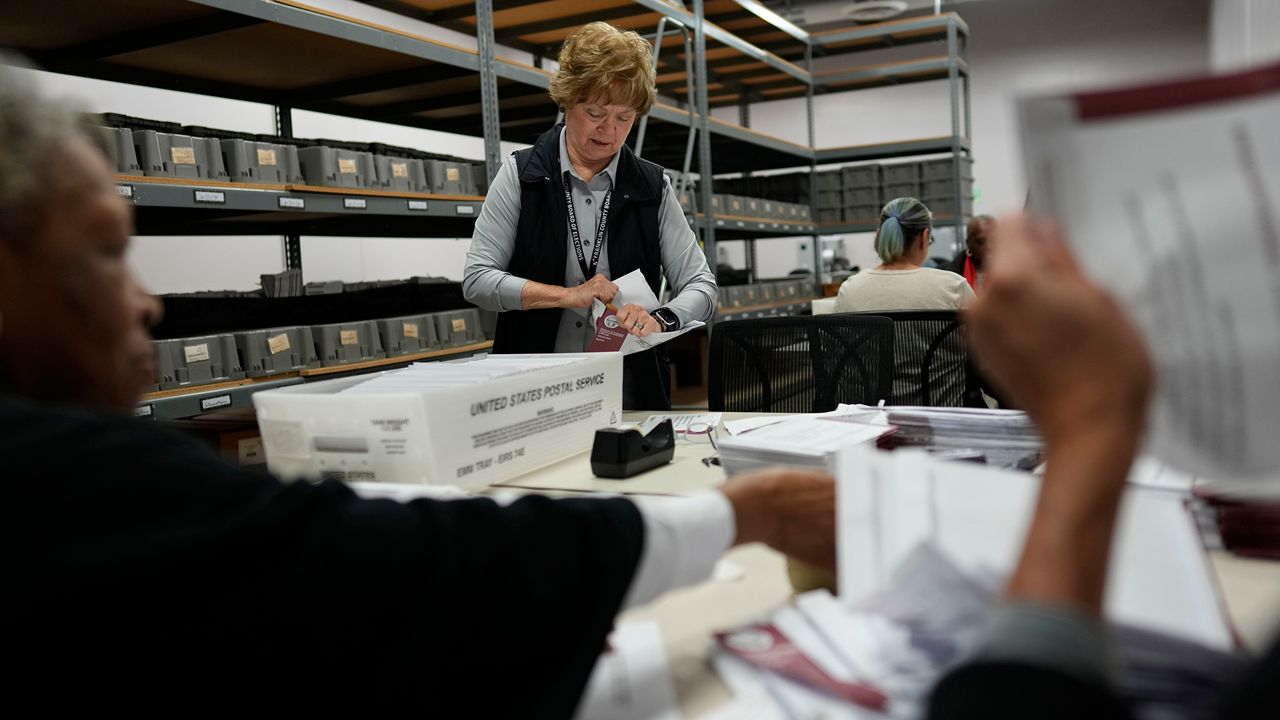 Election official Linda Sharritt, working on a bipartisan team, processes ballots on Election Day at the Franklin County Board of Elections in Columbus, Ohio, Tuesday, Nov. 7, 2023. (AP Photo/Carolyn Kaster)