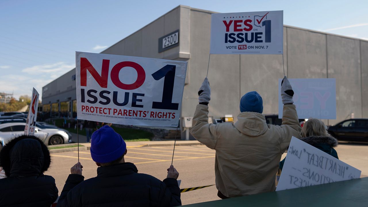 People gather in the parking lot of the Hamilton County Board of Elections as voters arrive for early in-person voting, in Cincinnati, Thursday, Nov. 2, 2023. They urge a vote for or against the measure known as Issue 1. Issue 1 is the only abortion question on any state ballot this year. (AP Photo/Carolyn Kaster)