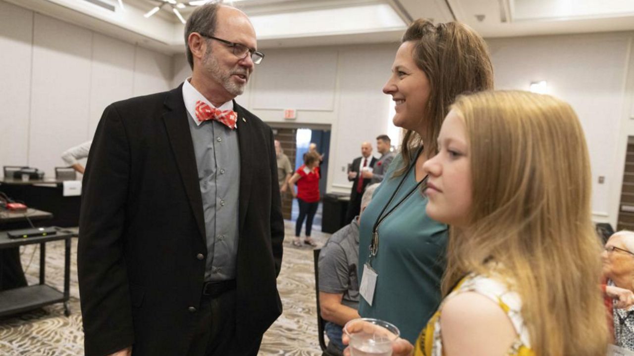 From left, Douglas Frank chats with Melissa Sauder and her daughter, Anley, 13, of Grant, Neb., before the start of the Nebraska Election Integrity Forum on Saturday, Aug. 27, 2022, in Omaha, Neb. (AP Photo/Rebecca S. Gratz)