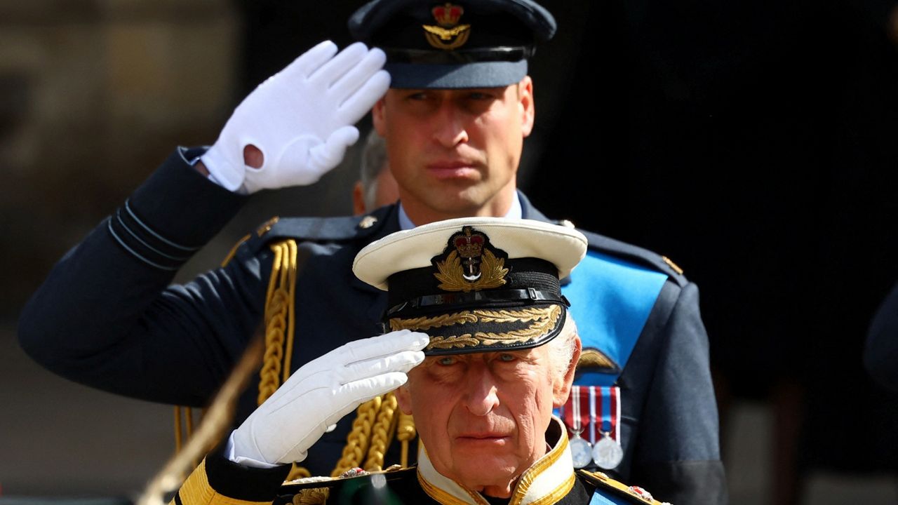 King Charles III and Prince William salute as they attend the state funeral of Queen Elizabeth. (Hannah Mckay/Pool Photo via AP)