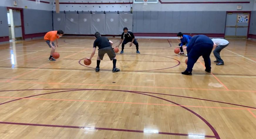 Elmcrest Community Center kids work on their ball skills on the basketball court.