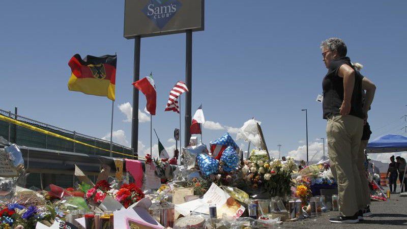 FILE - In this Aug. 12, 2019 photo, mourners visit the makeshift memorial near the Walmart in El Paso, Texas, where 22 people were killed in a mass shooting. (AP Photo/Cedar Attanasio, File)