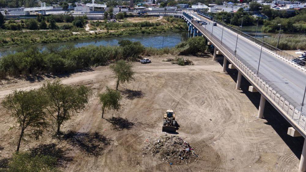 A bulldozer is seen next to a mound of debris while crews clear an area where migrants, many from Haiti, were encamped along the Del Rio International Bridge, Friday, Sept. 24, 2021, in Del Rio, Texas. (AP Photo/Julio Cortez)