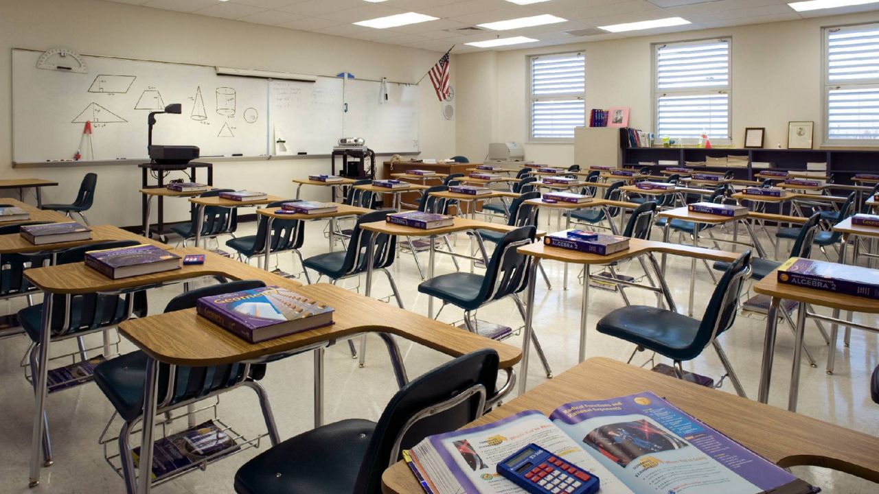 empty classroom with wooden desks and chairs. (Getty Images)