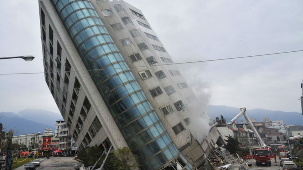 A residential building leans on a collapsed first floor following an earthquake, Feb. 7, 2018, in Hualien, Taiwan. (Central News Agency via AP)