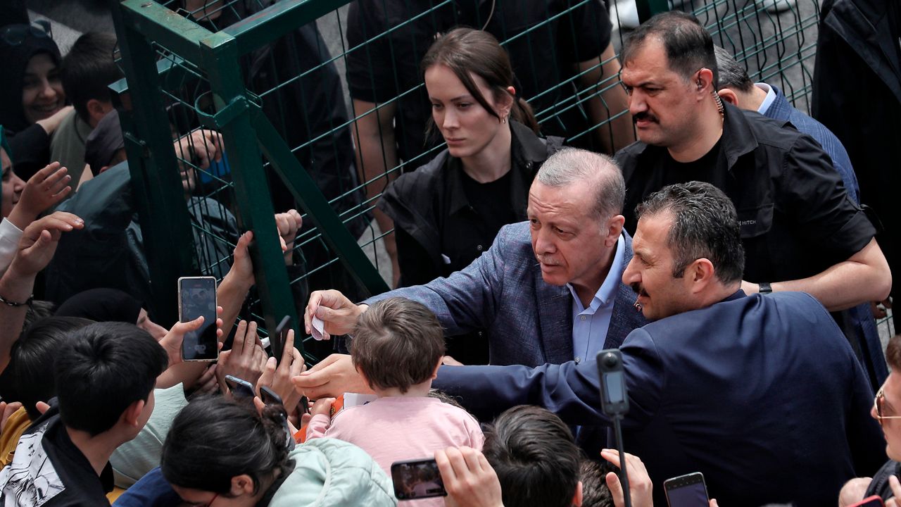 Turkey's President Recep Tayyip Erdogan with supporters at a polling station, in Istanbul, Turkey, Sunday, May 14, 2023. Election polls have closed Sunday in Turkey, where President Erdogan's leadership hung in the balance after a strong challenge from an opposition candidate. (DHA via AP)