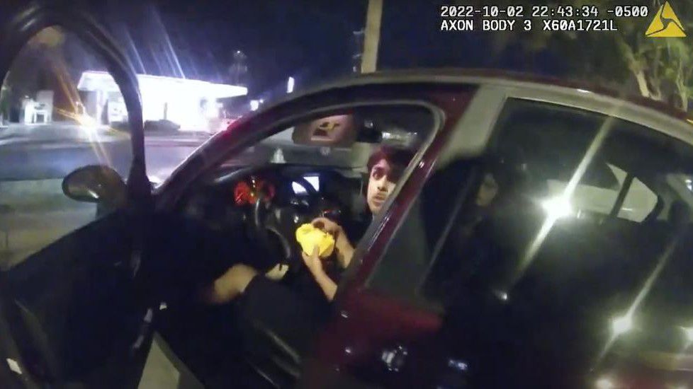 In this image taken from Oct. 2, 2022, police body camera video and released by the San Antonio Police Department, Erik Cantu looks toward San Antonio Police Officer James Brennand while holding a hamburger in a fast food restaurant parking lot as the officer opens the car door in San Antonio, Texas. Brennand opened fire several times, wounding the unarmed teenager as he drove away. Cantu has been released from the hospital, his family's lawyer said Wednesday, Nov. 23. (San Antonio Police Department via AP, File)