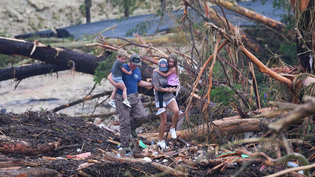 Una familia camina entre los escombros de un puente sobre el río Guadalupe tras la inundación que azotó la zona de Ingram, Texas. 