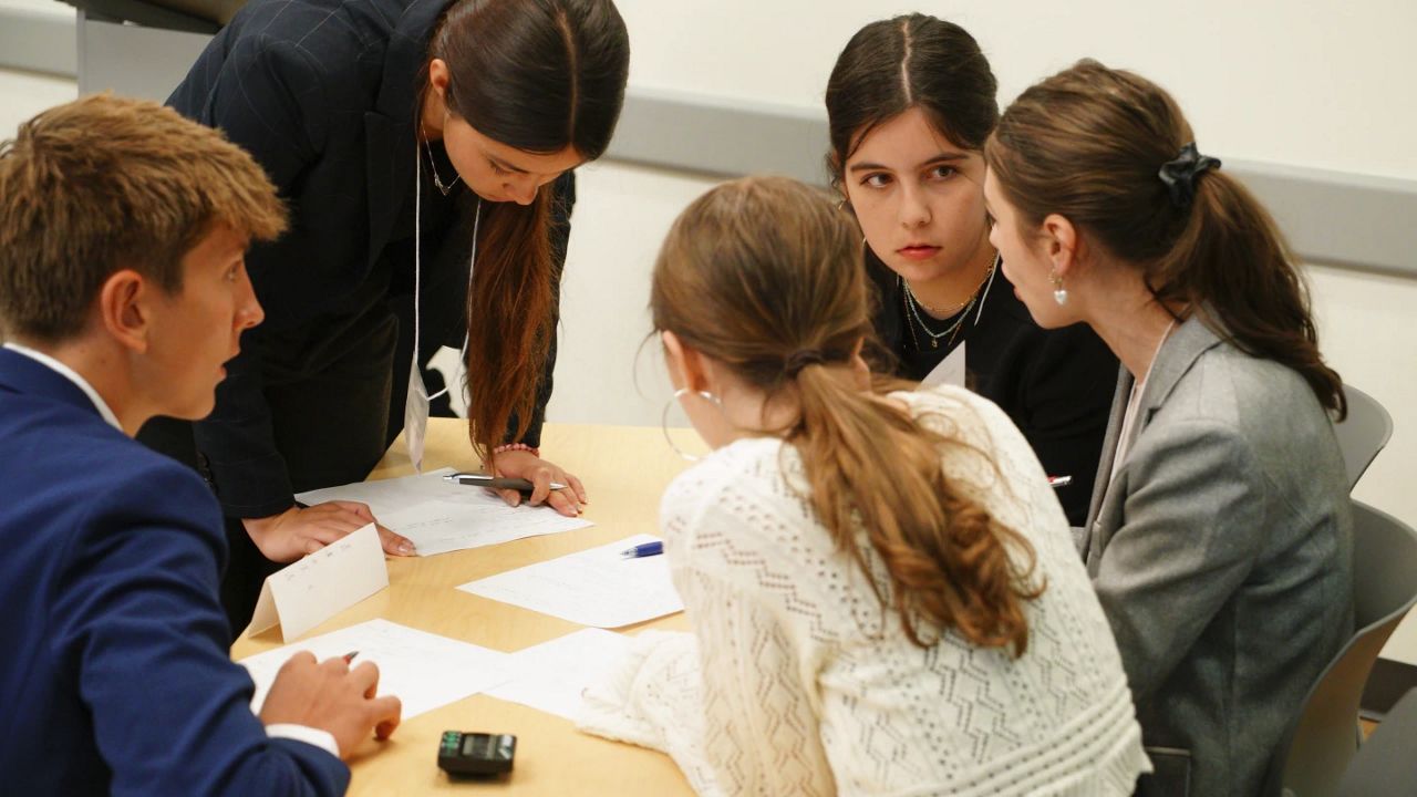 Kate Krugman, facing camera, and other students from Atlanta's Midtown High School confer during a semifinal round of the National High School Ethics Bowl in Chapel Hill, N.C., on Sunday, April 13, 2025. (AP Photo/Allen G. Breed)