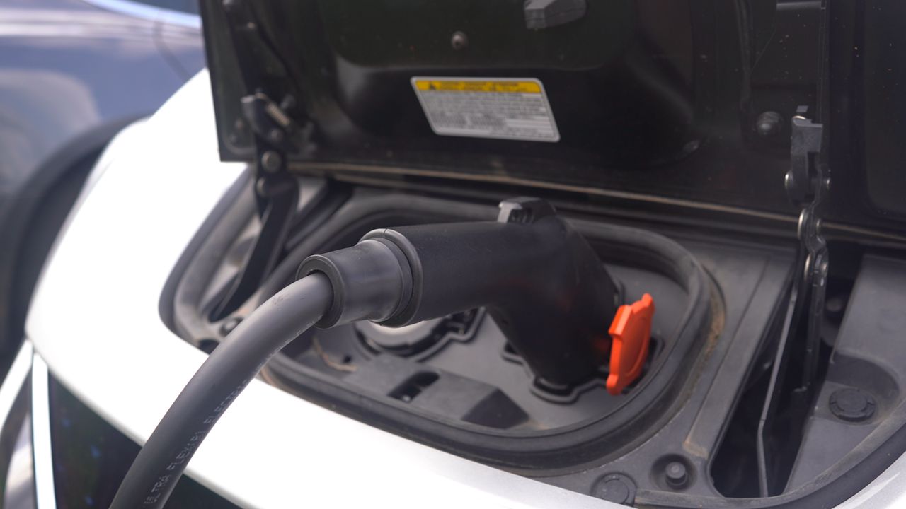 A driver charges their electric vehicle at a plug-in station in Louisville, Ky. (Spectrum News 1/Jonathon Gregg)