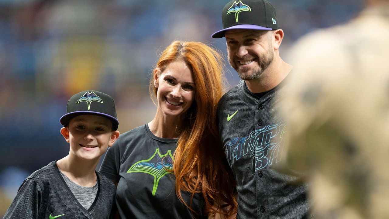 Former baseball player Evan Longoria, right, poses for a photo with wife Jaime, center, and son after throwing out a ceremonial first pitch before a baseball game between the Tampa Bay Rays and the Cleveland Guardians, Saturday, July.13, 2024, in St. Petersburg, Fla. (AP Photo/Chris Tilley)