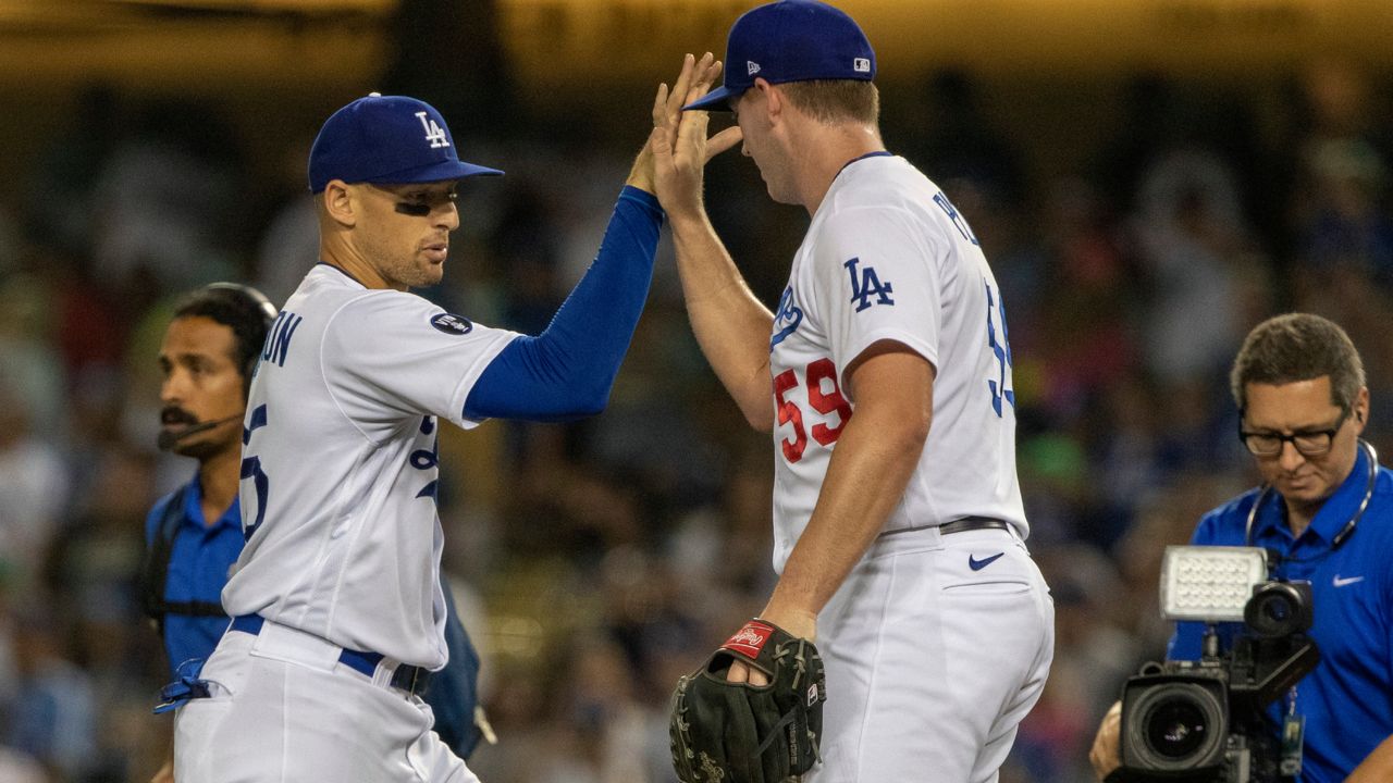 Los Angeles Dodgers relief pitcher Evan Phillips, right, celebrates with center fielder Trayce Thompson, left, after the team's baseball game against the Miami Marlins in Los Angeles, Friday, Aug. 19, 2022. (AP Photo/Alex Gallardo)