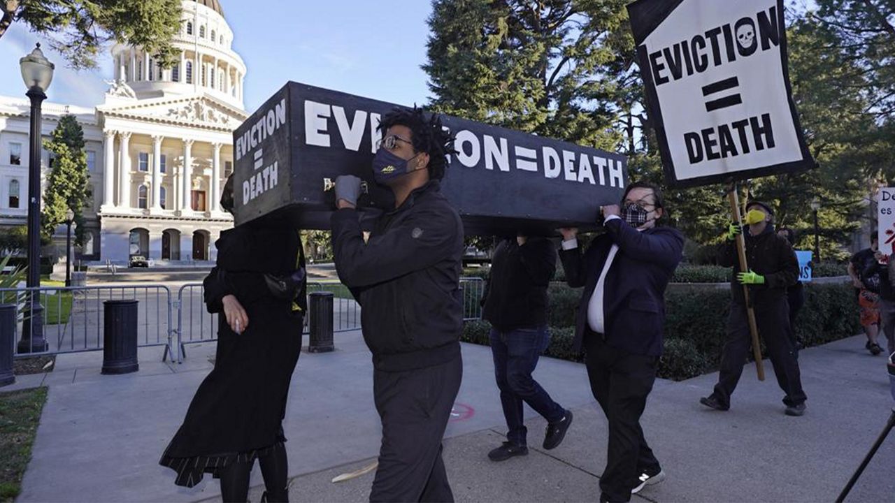 In this Jan. 25, 2021, file photo, demonstrators call passage of rent forgiveness and stronger eviction protections legislation and carry a mock casket past the Capitol in Sacramento, Calif. (AP Photo/Rich Pedroncelli, File)