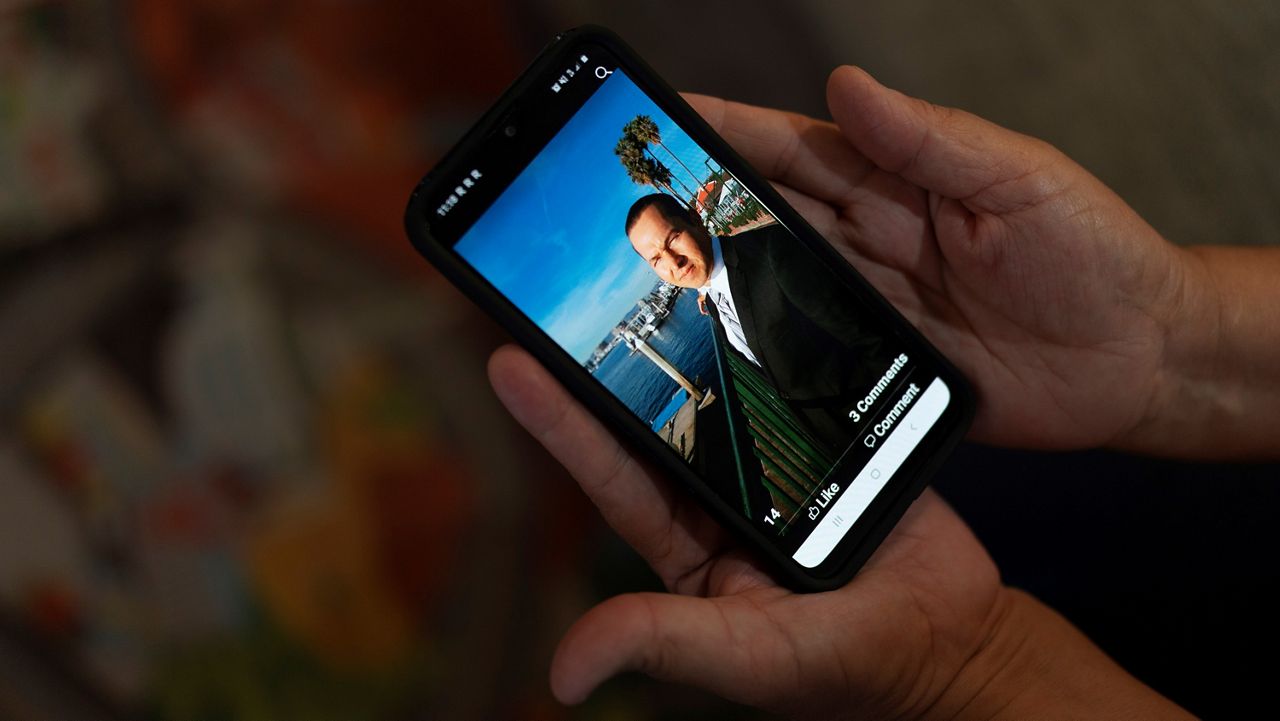 Ana Sandoval, mother of Eyvin Hernandez, a Los Angeles attorney who has been detained for five months in Venezuela, shows a photo of Hernandez in Compton, Calif., Monday, Aug. 29, 2022. (AP Photo/Jae C. Hong)