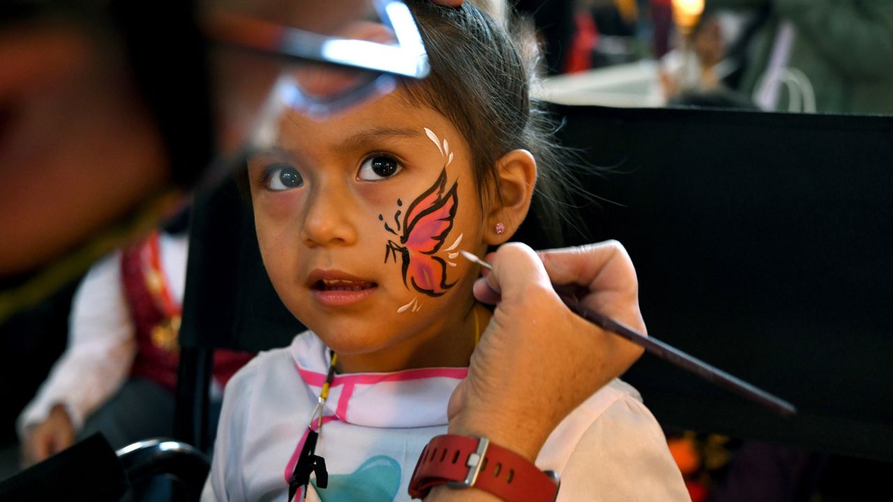 Michelle Alvarado, 4, has her face painted at a Halloween celebration at Denver's Union Station on Thursday, Oct. 28, 2021. (AP Photo/Thomas Peipert)
