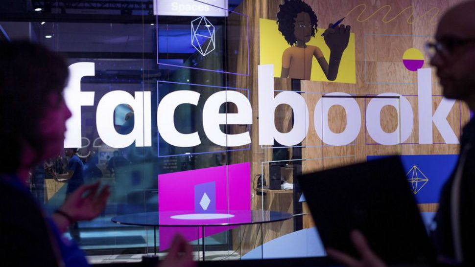 In this April 18, 2017, file photo, conference workers speak in front of a demo booth at Facebook's annual F8 developer conference in San Jose, Calif. (AP Photo/Noah Berger)
