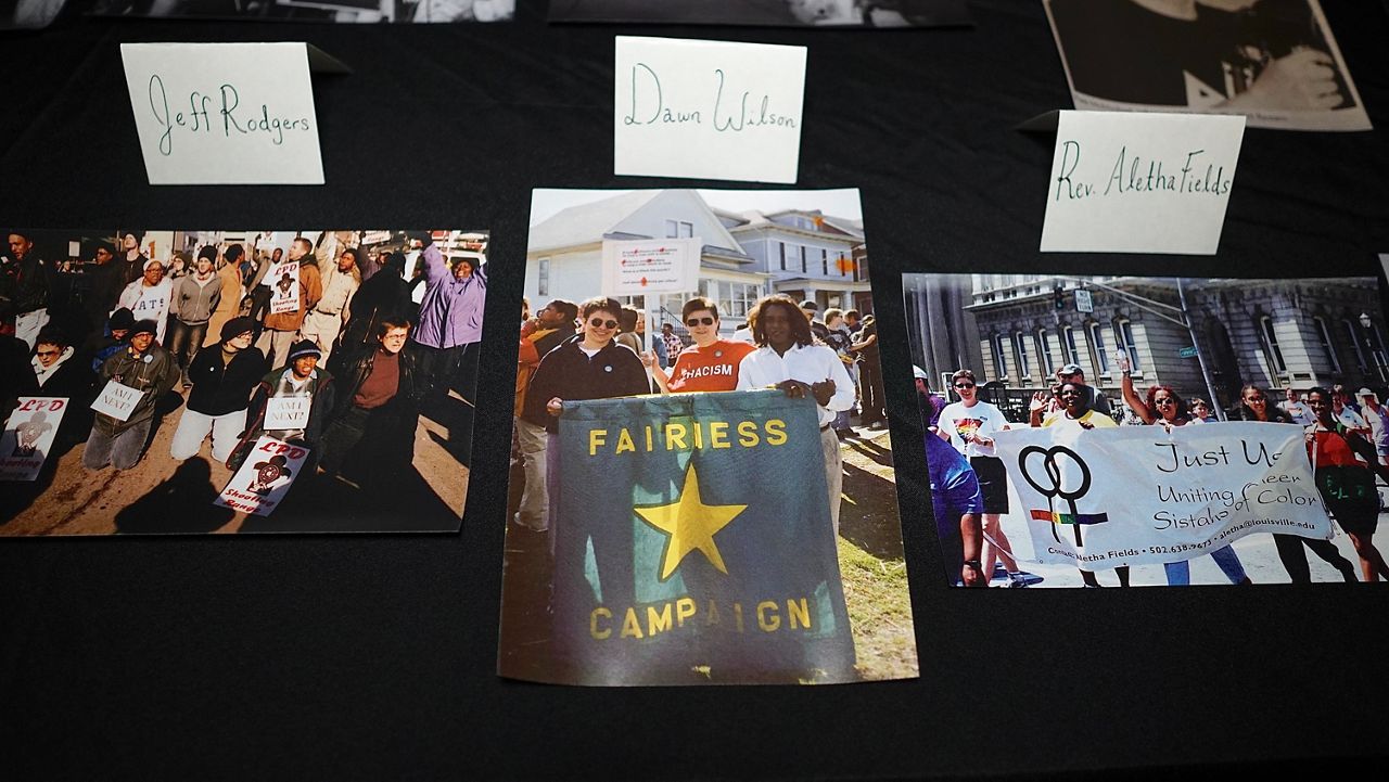 Dawn Wilson (right), and two others hold a Fairness Campaign banner in the early 2000s. The photos is one of several from the Campaign’s history featured at an event commemorating 25 years since Louisville passed the state’s first Fairness Ordinance (Spectrum News 1/Mason Brighton)