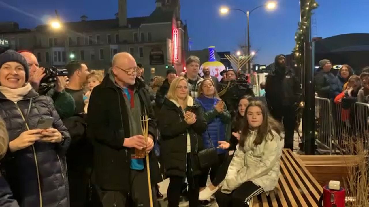 Families gather outside Firserv Forum on December 22, 2020, to light a basketball themed menorah.