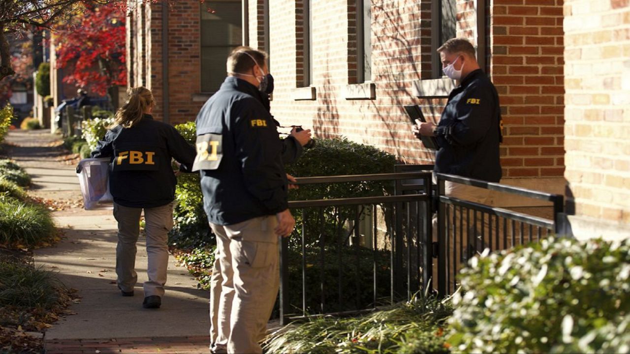 FILE-This Nov. 16, 2020 file photo shows FBI agents removing items from the home of then Public Utilities Commission of Ohio Chairman Sam Randazzo in Columbus, Ohio. State and federal officials are investigating whether Randazzo, the utility lawyer-turned-regulator who has since resigned, helped usher through a string of legislative and regulatory victories worth well over $1 billion over time to energy giant FirstEnergy Corp. and its subsidiaries, in exchange for cash. (Adam Cairns/The Columbus Dispatch via AP)