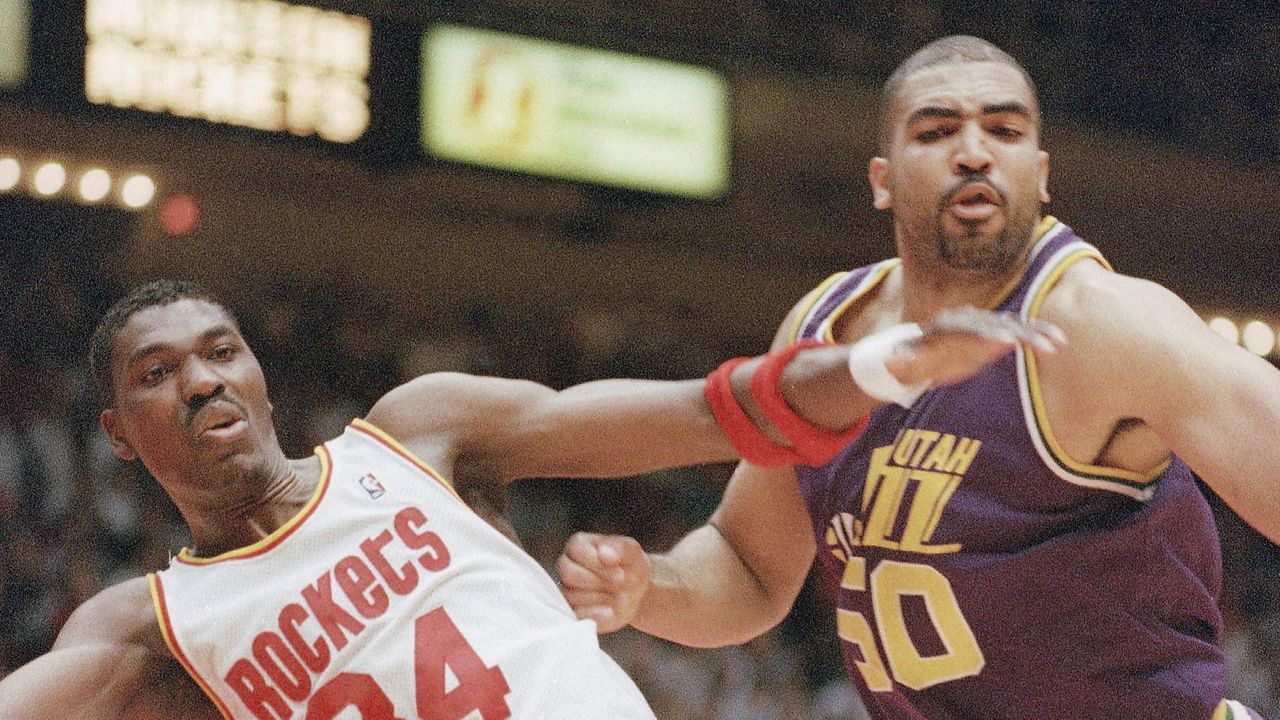 Houston Rockets' Hakeem Olajuwon (34) and Utah Jazz' Felton Spencer (50) react to the loose ball in the second half of the Western Conference Finals, on Tuesday, May 31, 1994 in Houston. The Rockets beat the Jazz 94-83 and advanced to the NBA Championship round. (AP Photo/Tim Johnson)