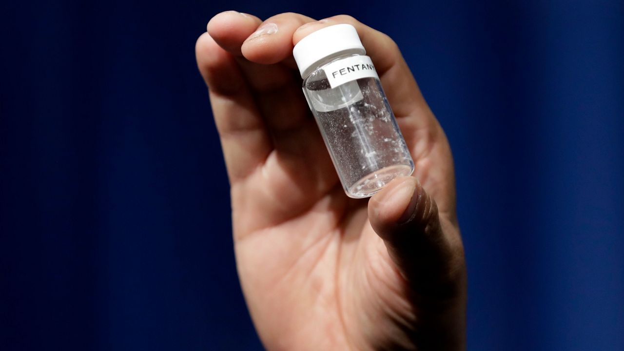 A reporter holds up an example of the amount of fentanyl that can be deadly after a news conference about deaths from fentanyl exposure on June 6, 2017, at DEA headquarters in Arlington, Va. (AP Photo/Jacquelyn Martin, File)