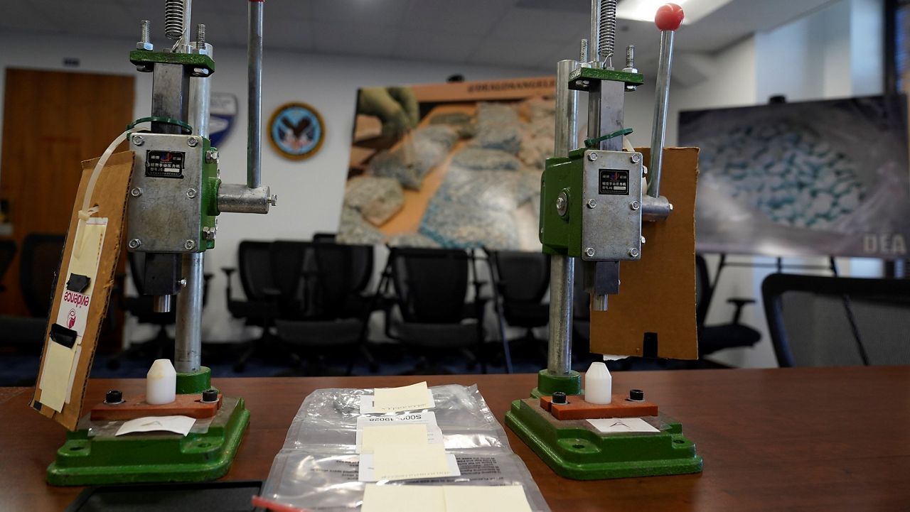 A couple of manual pill press machines used to mass-produce fake pills containing fentanyl sold on the dark net and through dealers openly operating on social media sites are displayed by the U.S. Attorney's Office Central District of California offices in Los Angeles, Monday, Nov. 21, 2022. (AP Photo/Damian Dovarganes)