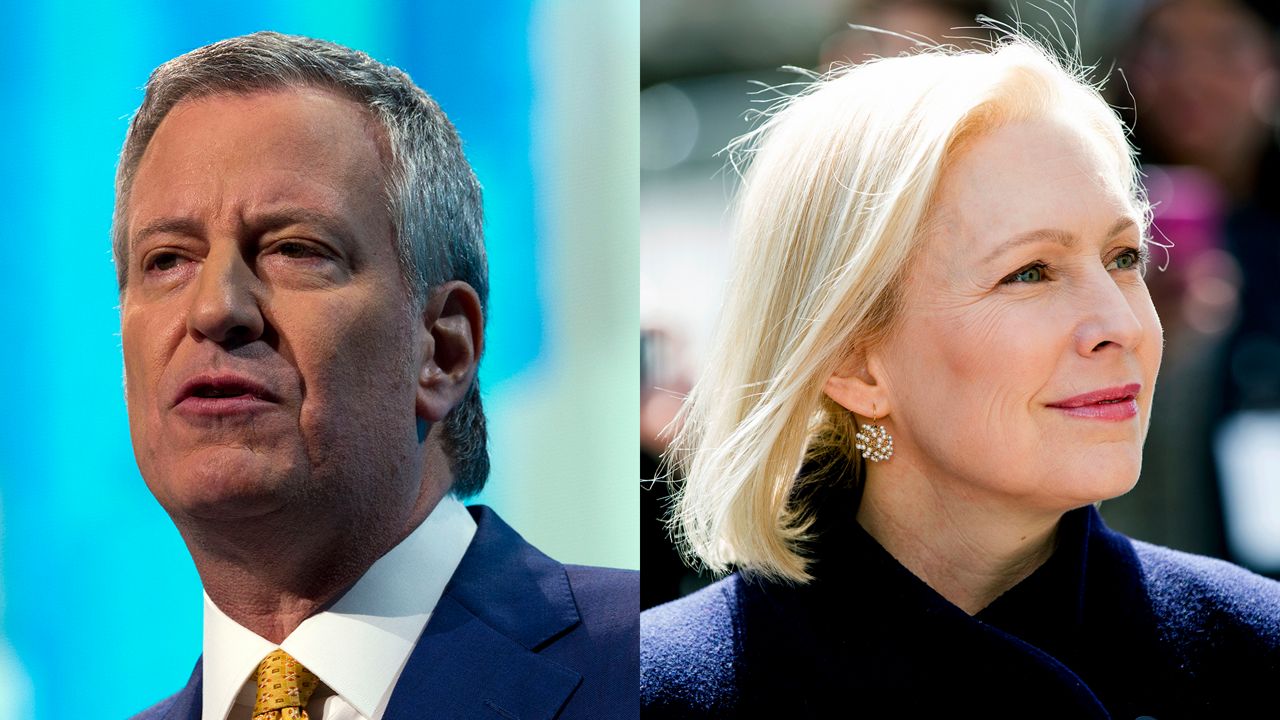 From left to right: Mayor Bill de Blasio, wearing a blue suit jacket, a white dress shirt, and a yellow tie; Sen. Kirsten Gillibrand, wearing earrings and a navy blue blazer.