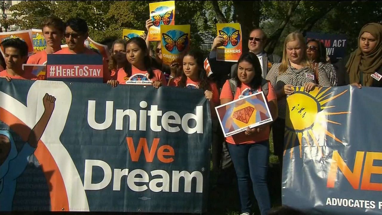 A group of people hold signs and banners