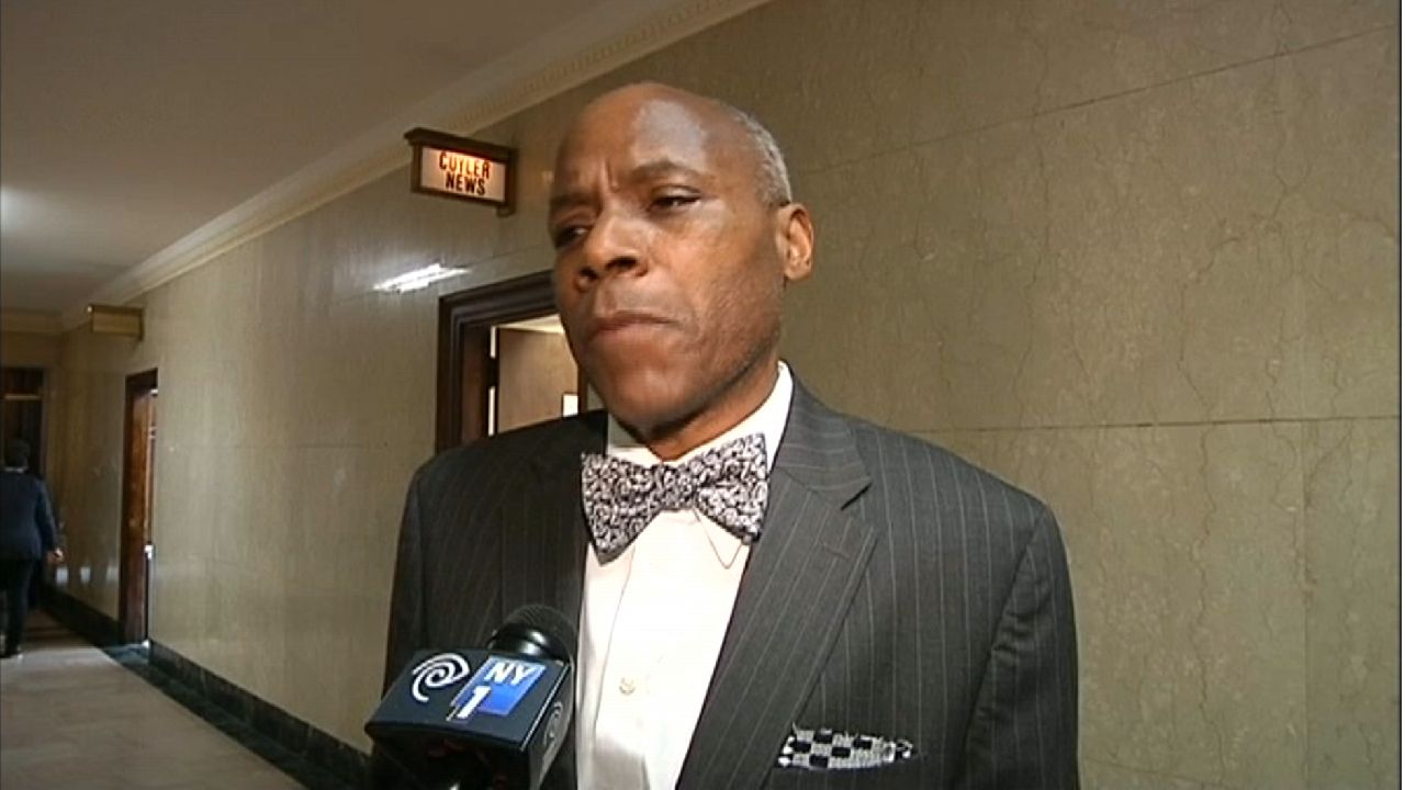 A file photo of Manhattan Councilman Bill Perkins, wearing a black blazer with vertical white stripes, a white dress shirt, and a bow tie.