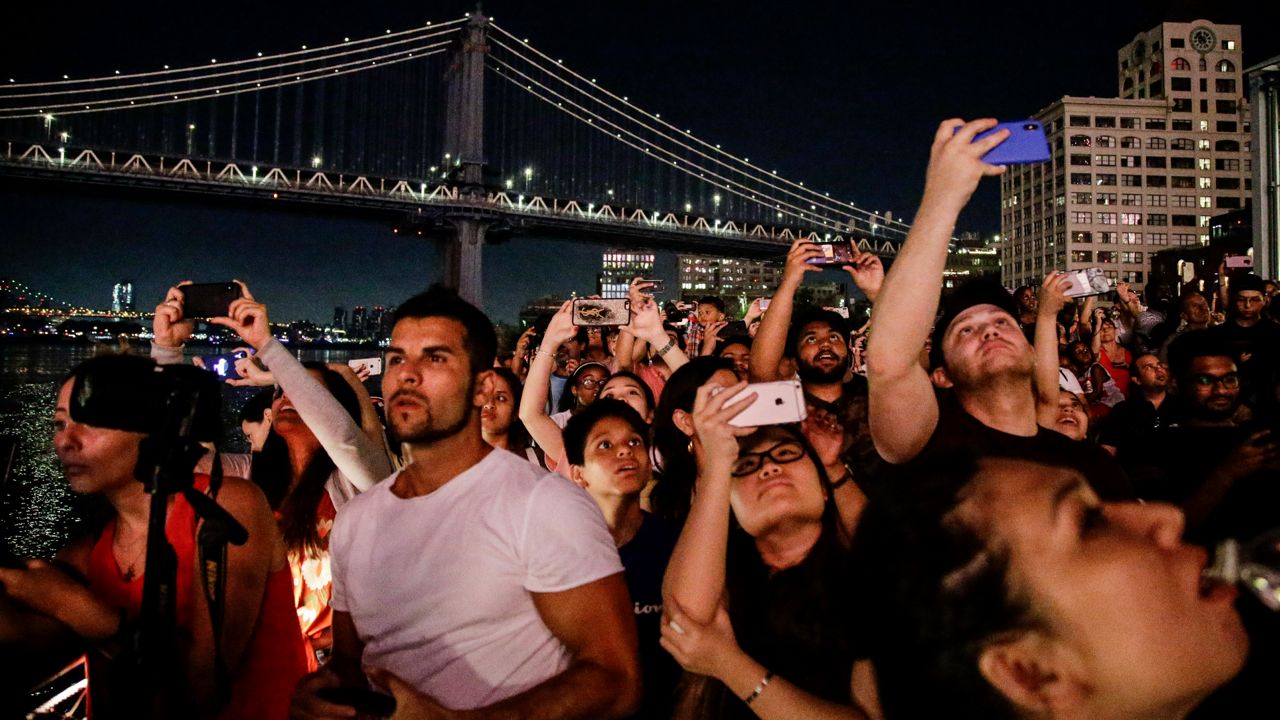 Spectators watching fireworks launched from the Brooklyn Bridge on July 4, 2019. (AP Photo/Frank Franklin II)