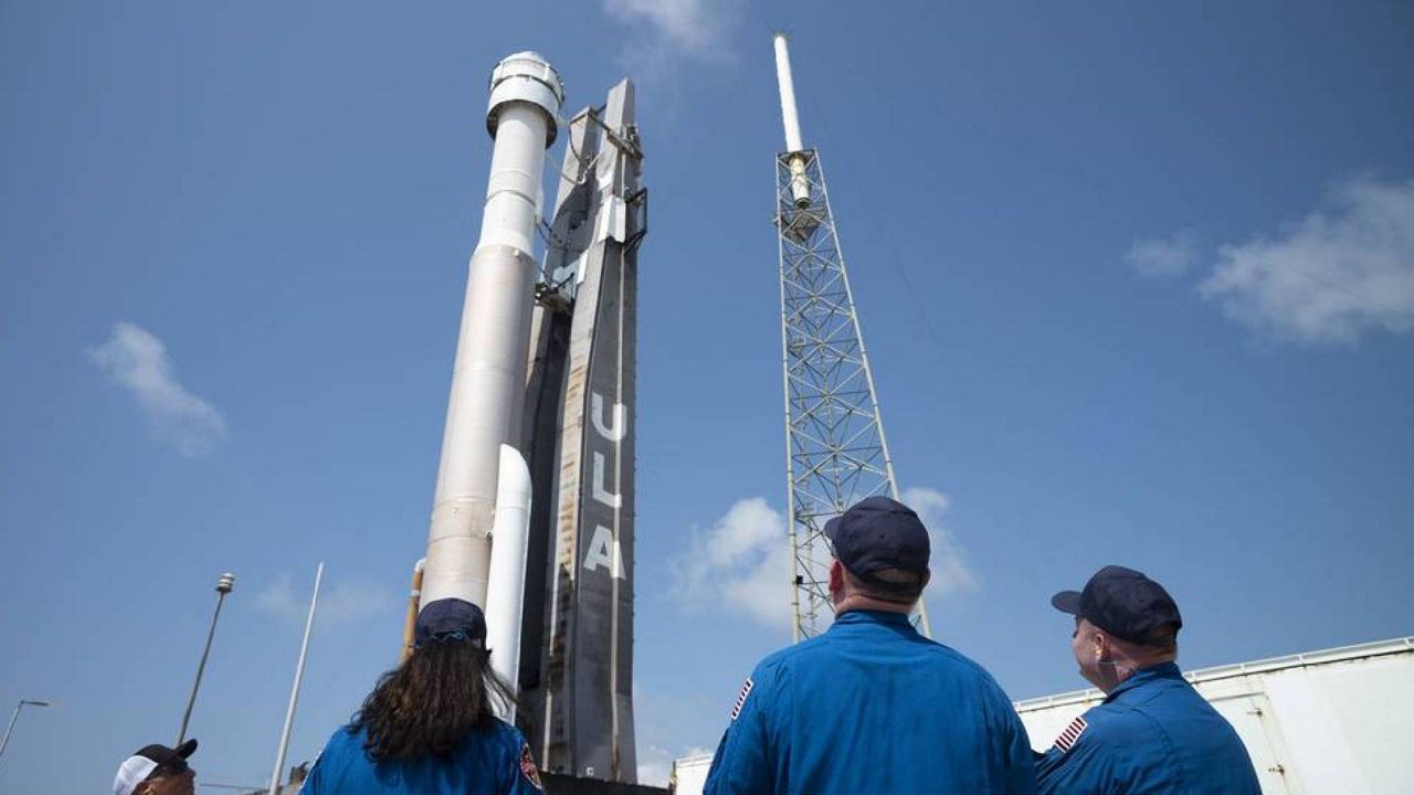 NASA astronauts Suni Williams, left, Barry "Butch" Wilmore, center, and Mike Fincke, right, watch as a United Launch Alliance Atlas V rocket with Boeing’s CST-100 Starliner spacecraft aboard is rolled out of the Vertical Integration Facility to the launch pad at Space Launch Complex 41 ahead of the Orbital Flight Test-2 (OFT-2) mission, Wednesday, May 18, 2022, at Cape Canaveral Space Force Station in Florida. (NASA/Joel Kowsky)