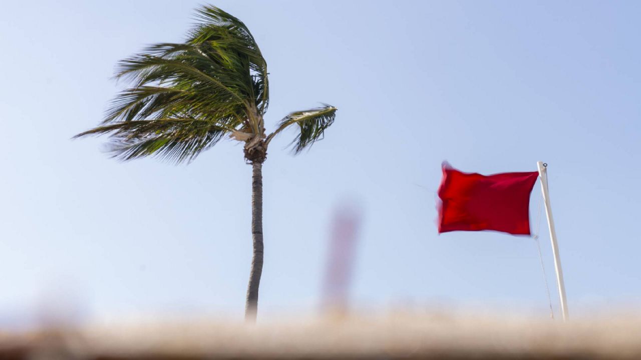 A red flag, signaling high surf and strong currents, flies in strong wind on the beach in Palm Beach, Fla., Tuesday, Nov. 8, 2022, as Tropical Storm Nicole continues to increase in strength and is expected to make landfall along Florida's east coast early Thursday. (AP Photo/Andrew Harnik)