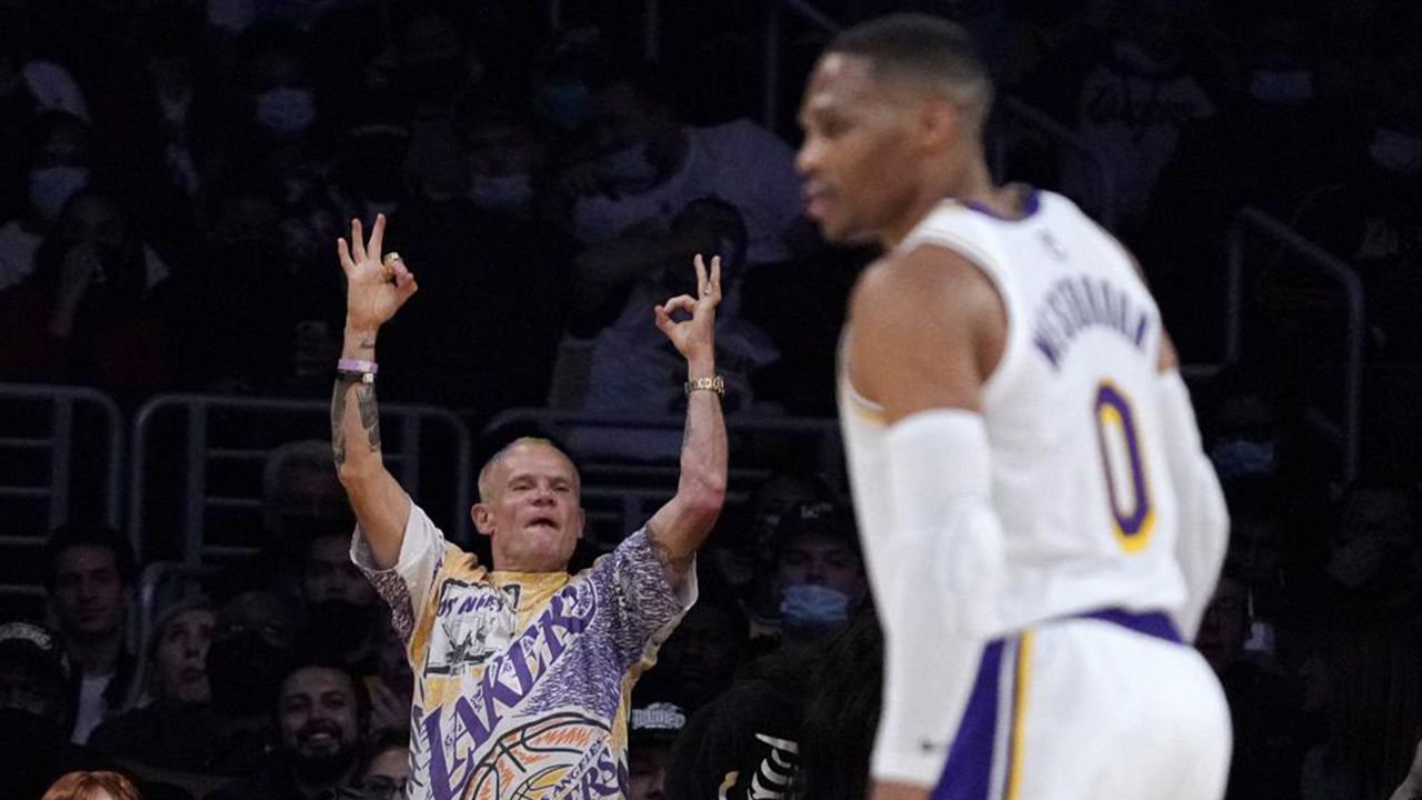 Red Hot Chili Peppers bass player Michael Balzary, known professionally as Flea, cheers after the Los Angeles Lakers scored as guard Russell Westbrook stands on the court during the first half of an NBA basketball game against the Houston Rockets Sunday, Oct. 31, 2021, in Los Angeles. (AP Photo/Mark J. Terrill)