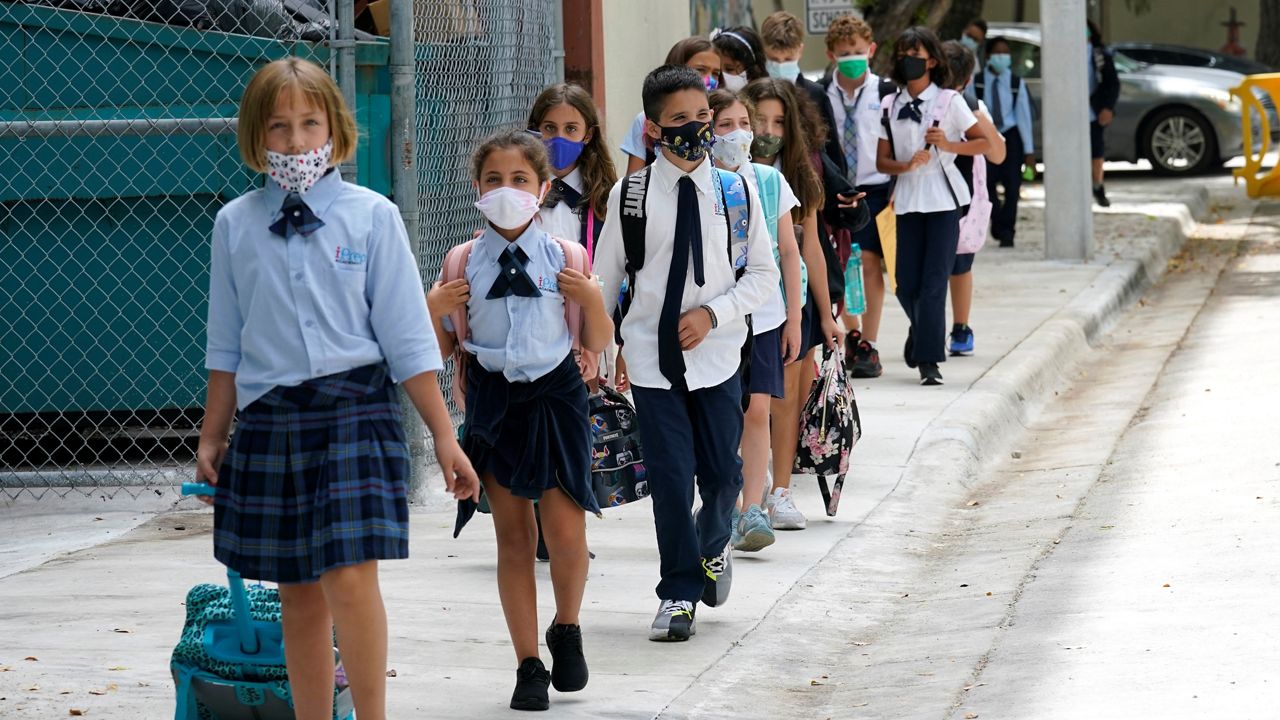 Students walk from iPrep Academy on the first day of school, Monday, Aug. 23, 2021, in Miami. Schools in Miami-Dade County opened Monday with a strict mask mandate to guard against coronavirus infections. (AP Photo/Lynne Sladky)