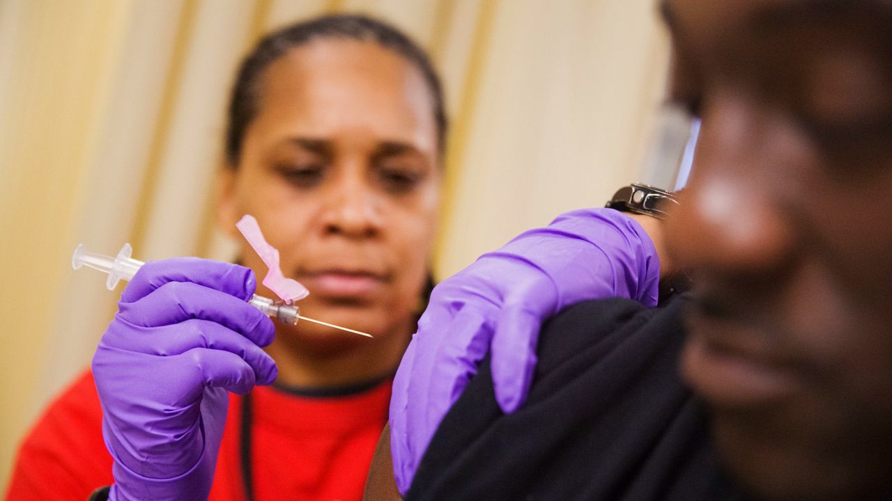 Todd Nelson, right, gets a flu shot from nurse Nicole Simpson at the Salvation Army in Atlanta, on Feb. 7, 2018. (AP Photo/David Goldman)