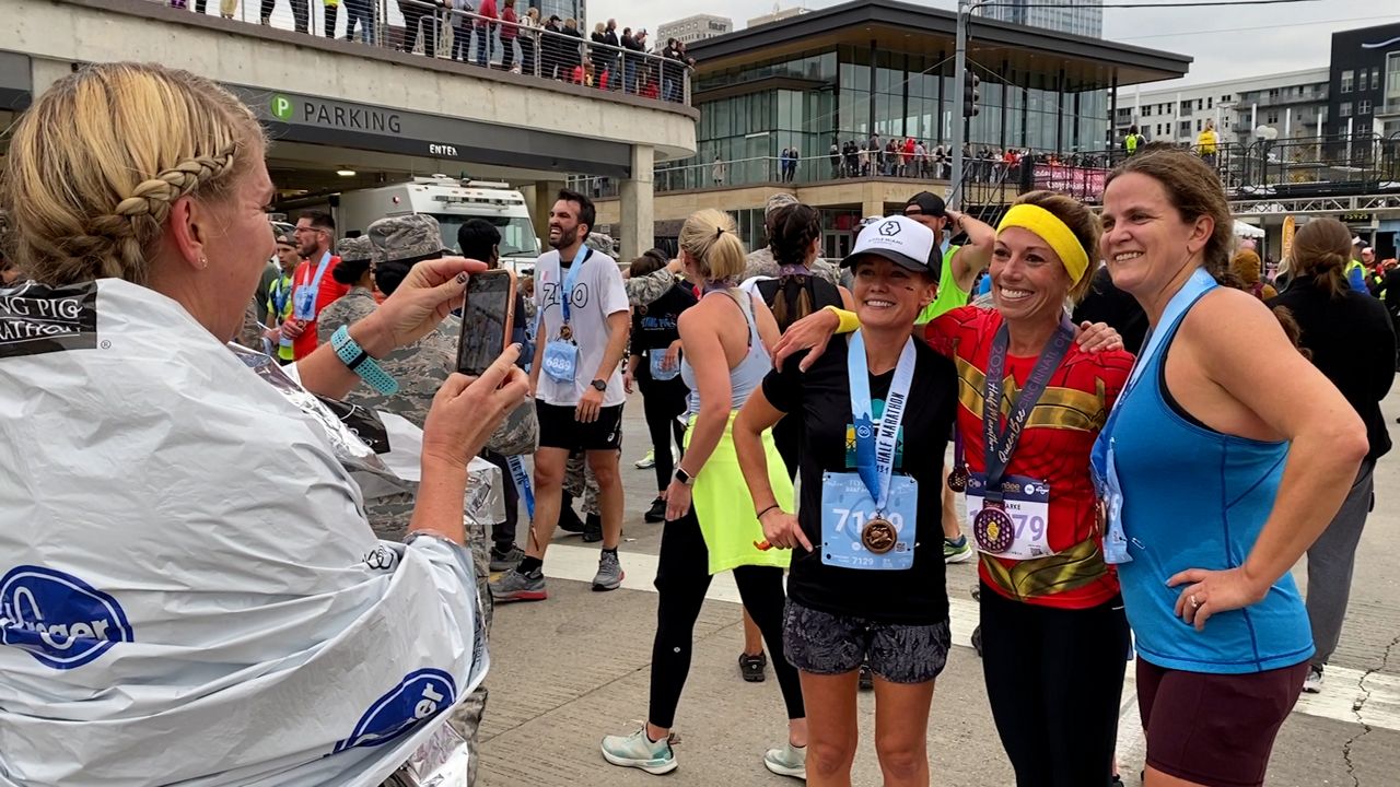 Flying Pig Marathon participants pose at the finish line after completing the race.