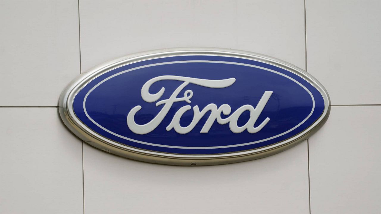 FILE - The Ford logo is seen on signage at a Ford dealership, Tuesday, July 27, 2021. The National Highway Traffic Safety Administration is investigating a Ford Motor Co. recall of more than a quarter-million Explorer SUVs in the U.S. after receiving complaints about repairs intended to prevent the vehicles from unexpectedly rolling away even while placed in “park” gear. (AP Photo/Gerry Broome, File)