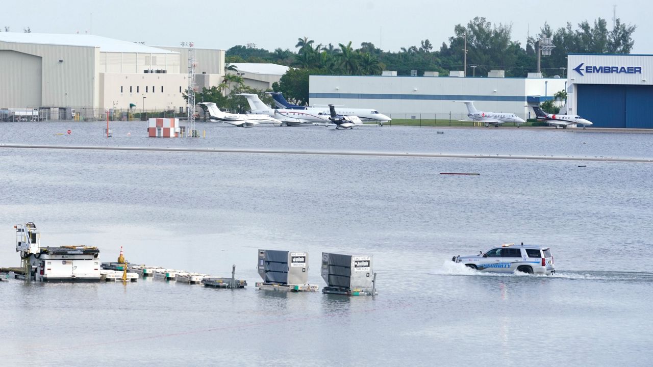 A truck drives on the flooded runway at Fort Lauderdale-Hollywood International Airport on Thursday. The airport remains closed until 5 a.m. Friday, and Fort Lauderdale issued a state of emergency as flood conditions continued through many areas. (AP Photo/Marta Lavandier)