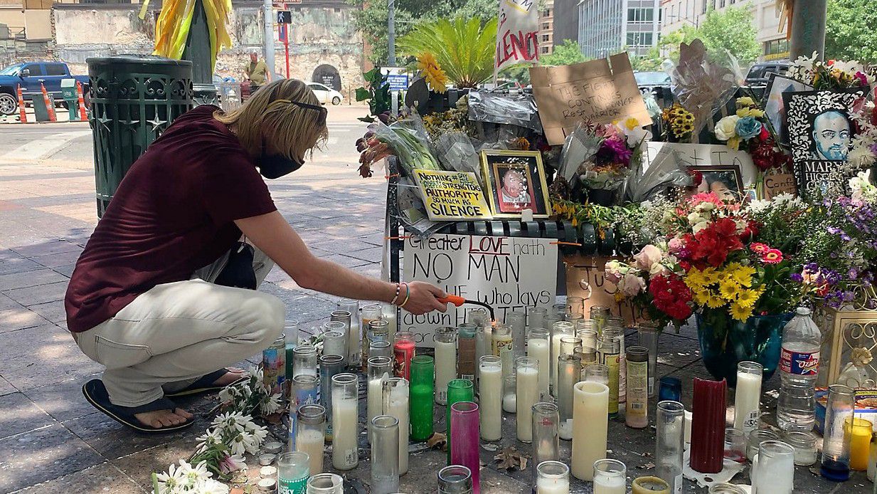 Adam Cartwright lights a candle at Garrett Foster's memorial in this file image. (Spectrum News 1/Niki Griswold)
