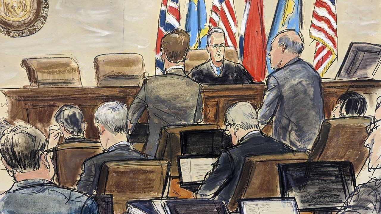 This artist sketch depicts Dominion Voting Systems attorney Justin Nelson, standing left, and Fox News attorney Daniel Webb, standing at right, speaking to Judge Eric Davis Tuesday before finishing jury selection in Delaware Superior Court in Wilmington, Del. (Elizabeth Williams via AP)