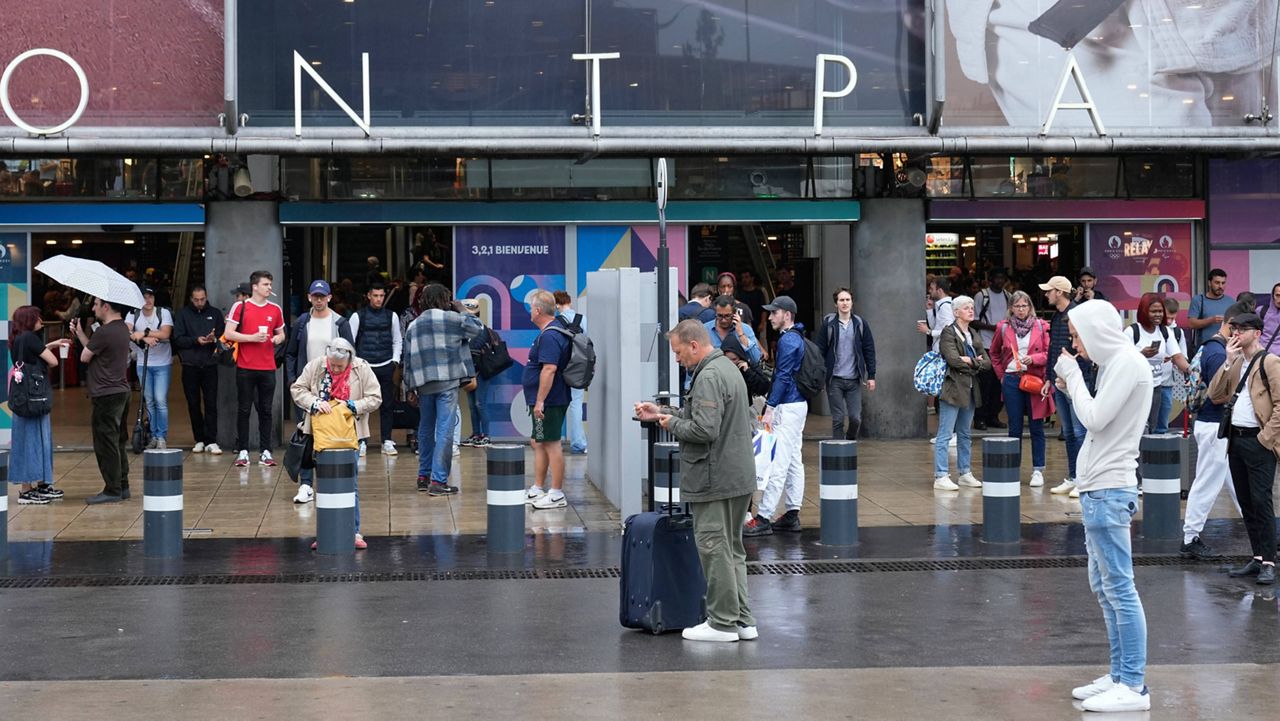 Travelers wait outside the Gare de Montparnasse train station, at the 2024 Summer Olympics, Friday, July 26, 2024, in Paris, France. (AP Photo/Yasin Dar)