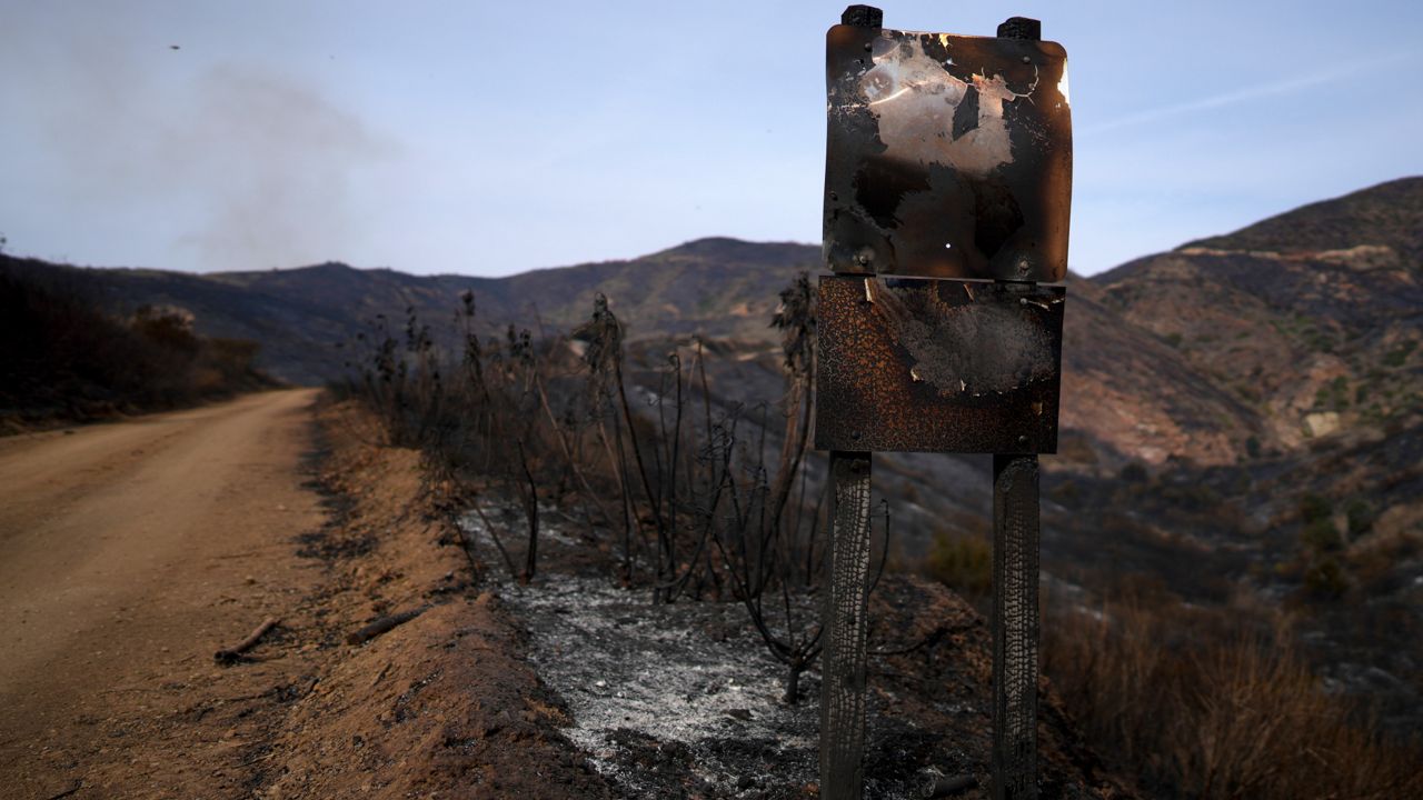 A road signed is burned Wednesday after the Franklin Fire swept through in Malibu, Calif. (AP Photo/Eric Thayer)