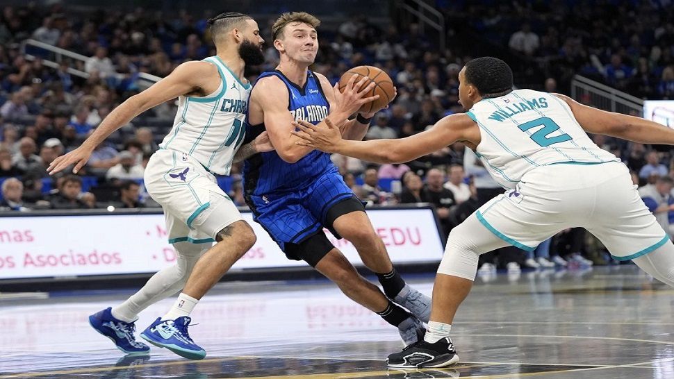 Add to BoardShare linkDownload comp Orlando Magic forward Franz Wagner, center, drives between Charlotte Hornets forward Cody Martin, left, and forward Grant Williams (2) during the second half of an Emirates NBA Cup basketball game, Tuesday, Nov. 12, 2024, in Orlando, Fla. (AP Photo/John Raoux)