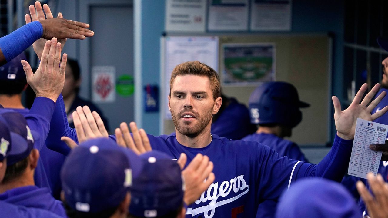 The Los Angeles Dodgers' Freddie Freeman is congratulated by teammates in the dugout after scoring during a spring training game against the Los Angeles Angels on Tuesday. (AP Photo/Mark J. Terrill)