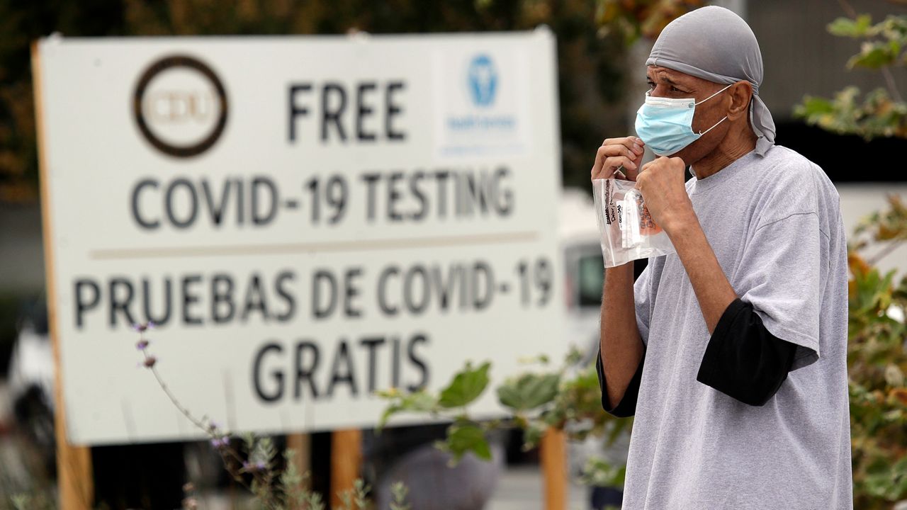 A man takes a coronavirus test at a mobile site at the Charles Drew University of Medicine and Science Wednesday, July 22, 2020, in Los Angeles. California has surpassed New York for the most coronavirus cases in the country, reporting more than 409,000 infections after setting a record on Tuesday for the state's most confirmed new cases in a single day since the start of the pandemic. (AP Photo/Marcio Jose Sanchez)