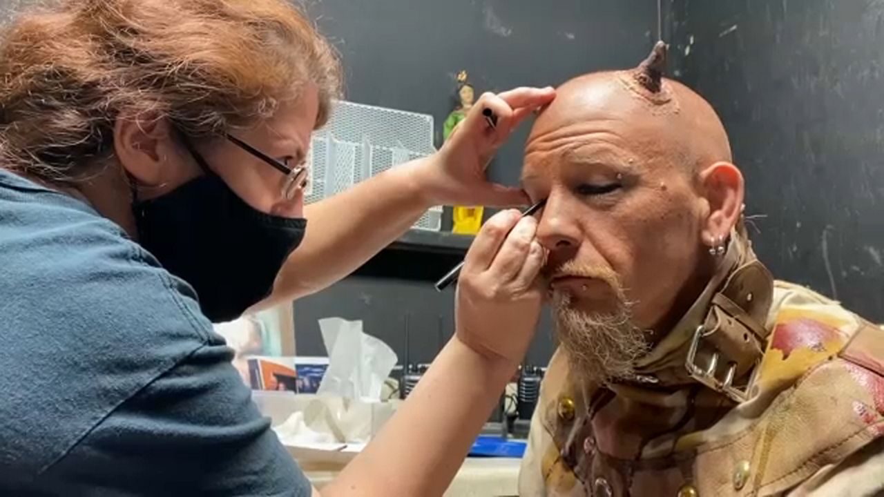 A performer having makeup applied under a new, sanitized procedure. 