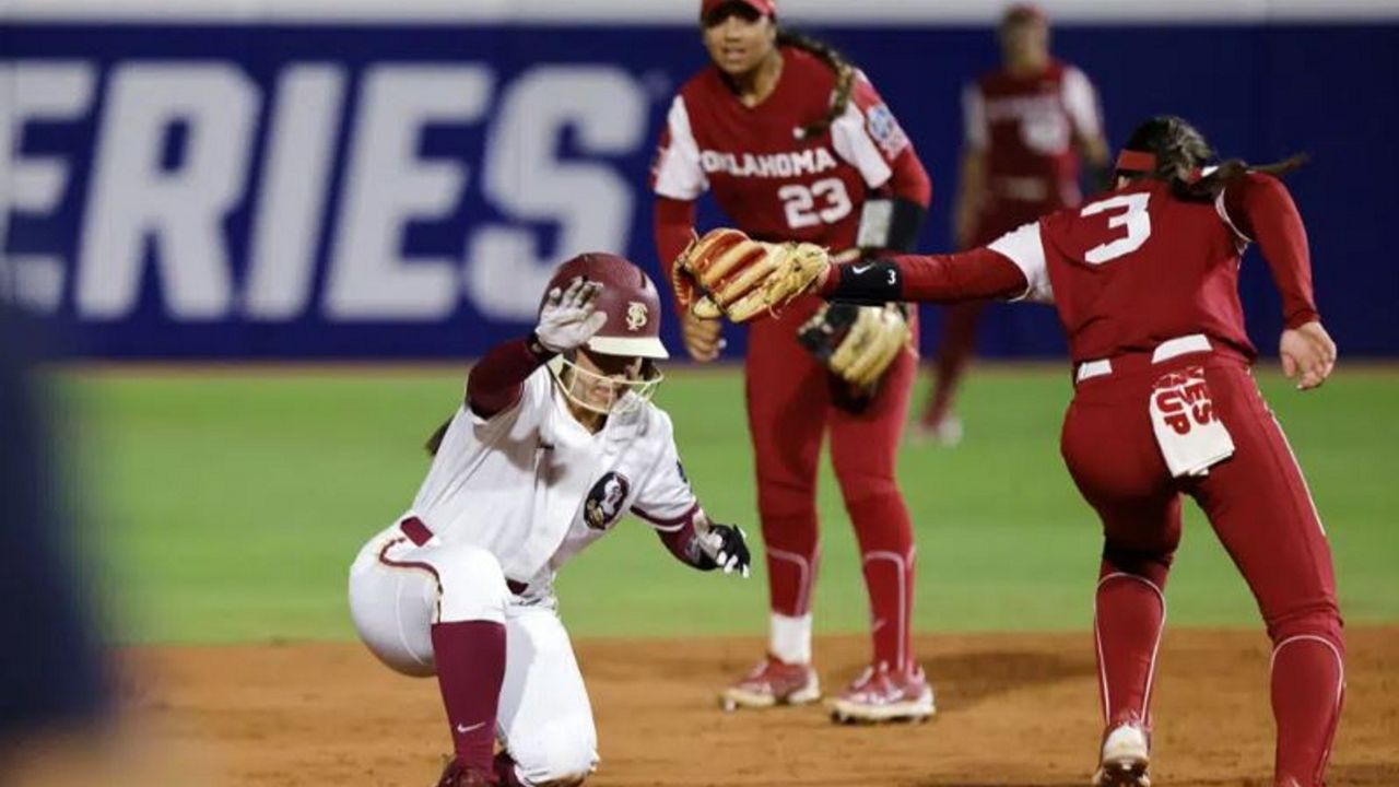 Florida State's Hallie Wacaser, left, steals second base past Oklahoma's Grace Lyons (3) during the third inning of the first game of the NCAA Women's College World Series softball championship series Wednesday, June 7, 2023, in Oklahoma City. (AP Photo/Nate Billings)