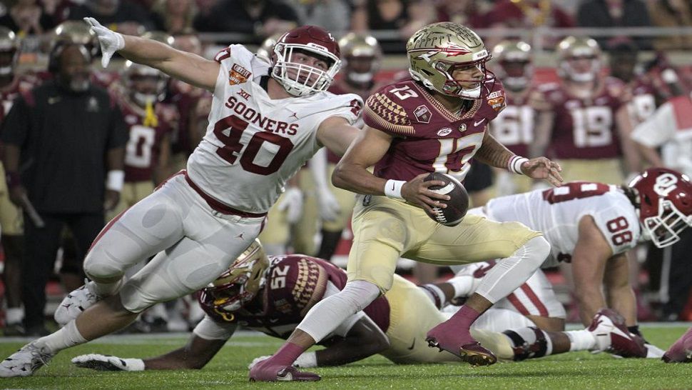 Florida State quarterback Jordan Travis scrambles away from Oklahoma defensive lineman Ethan Downs during the first half of the Cheez-It Bowl Thursday, Dec. 29, 2022, in Orlando, Fla. (AP Photo/Phelan M. Ebenhack)