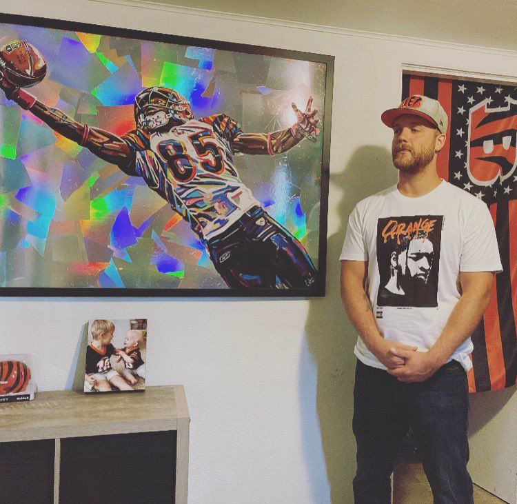 Tyler Thurston poses near a painting of Chad Johnson. (Provided)