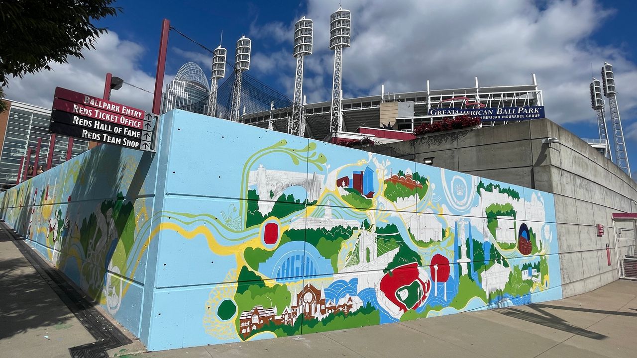 An in-progress look at a mural being painted outside Great American Ball Park. The mural features Cincinnati landmarks found along the CROWN trail, a planned 34-mile, mixed-used paved pathway. (Photo courtesy of Lora Jost)